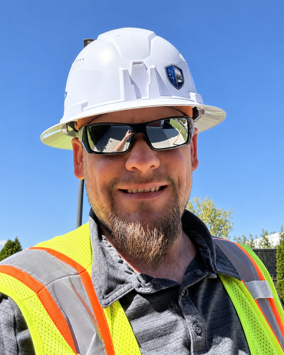 Michael Smolar, Owner and Lead Safety Consultant, wearing a white hard hat and high-visibility vest.